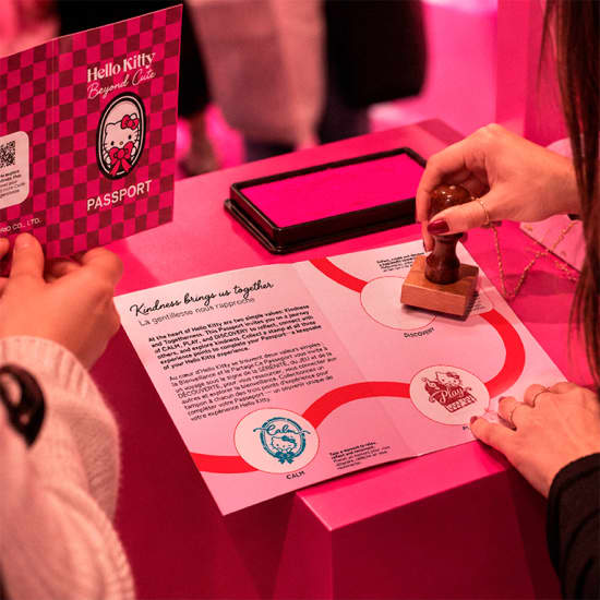 Visuel promotionnel Hello Kitty: Beyond Cute montrant le carnet et un bijou de sac.